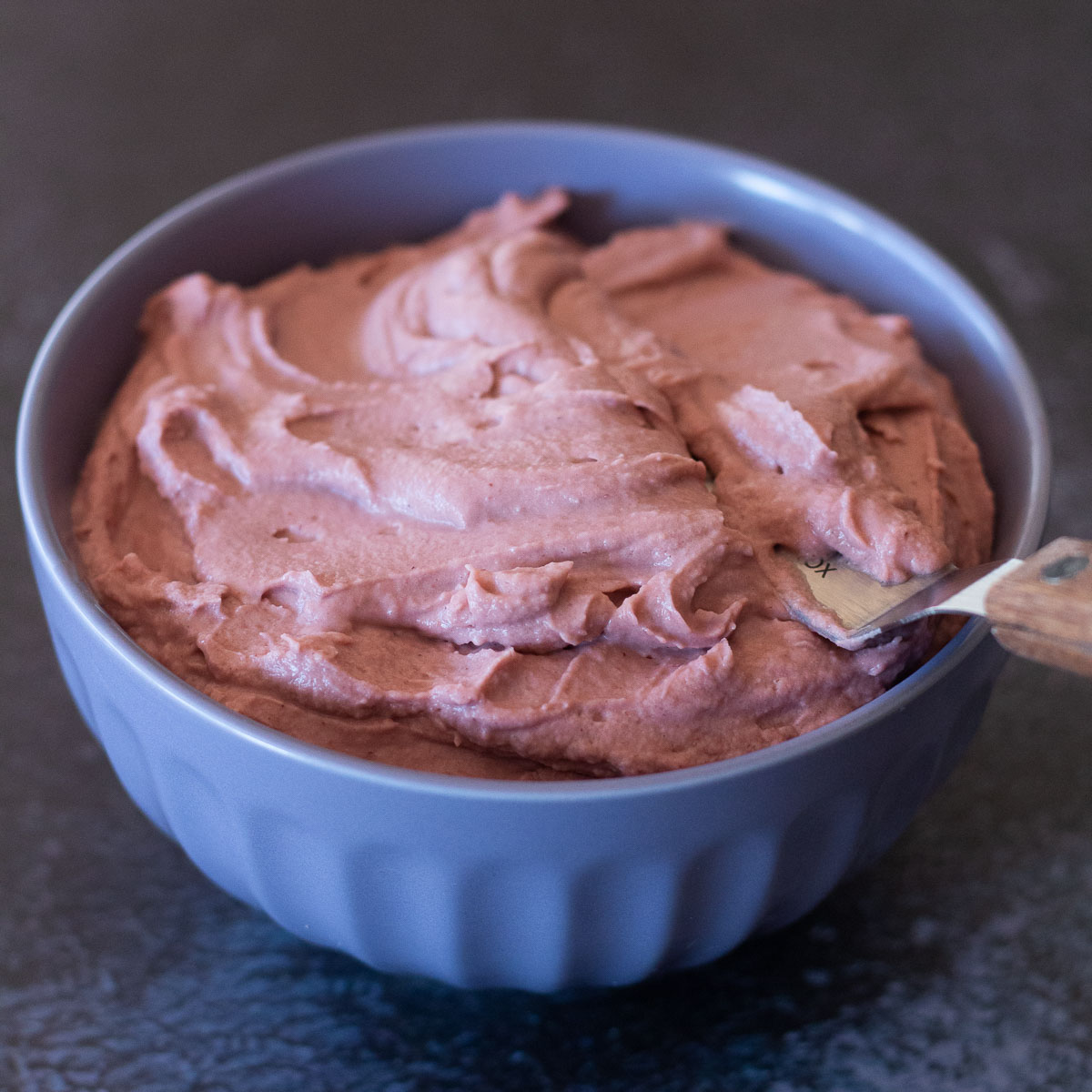 Dairy free strawberry frosting in a bowl, ready to frost some cakes!