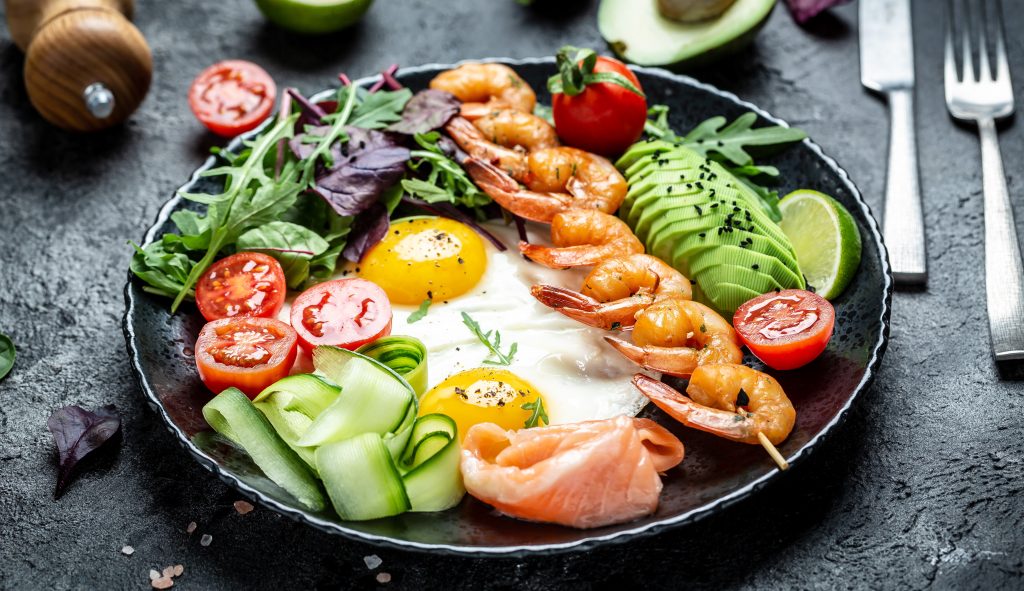 SIBO Diet breakfast plate with zucchini, tomato, smoked salmon, eggs, prawns and avocado